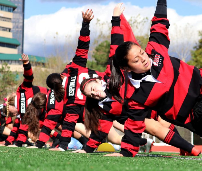 MONTCLAIR, NJ 11/01/2019 WARMING UP LIKE A TEAM: Montclair State University’s Women’s Club Rugby player Andrea Esquibel Berniz (#2) warms up for the game along with the Lady Revelers by doing side planks by Yogi Berra Stadium. -Photo by Sunah E. Choudhry